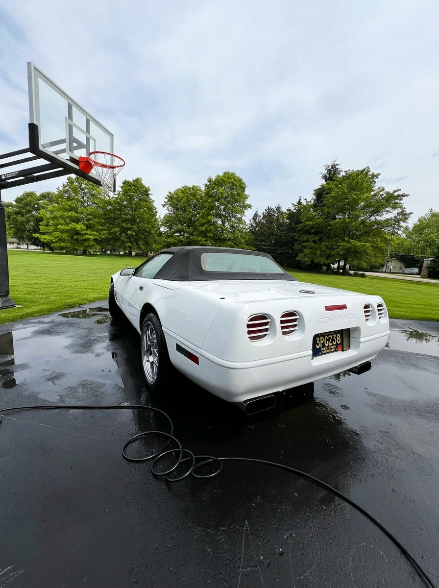 White Corvette freshly detailed on wet pavement
